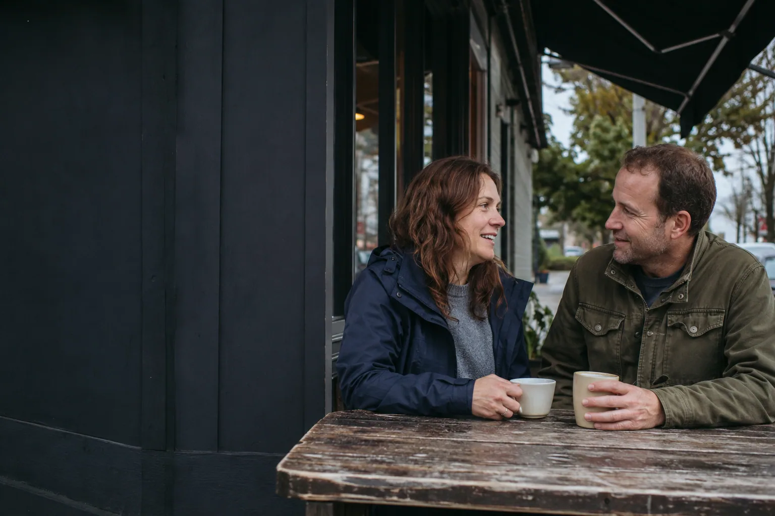 Two adults enjoying a relaxed coffee date outside a Washington neighborhood café